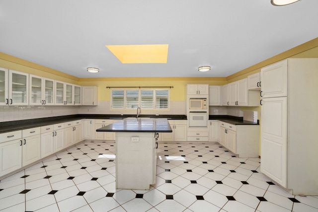 4879 Lani Rd, Kapaa, HI 96746 - kitchen with white appliances, dark countertops, glass insert cabinets, and backsplash
