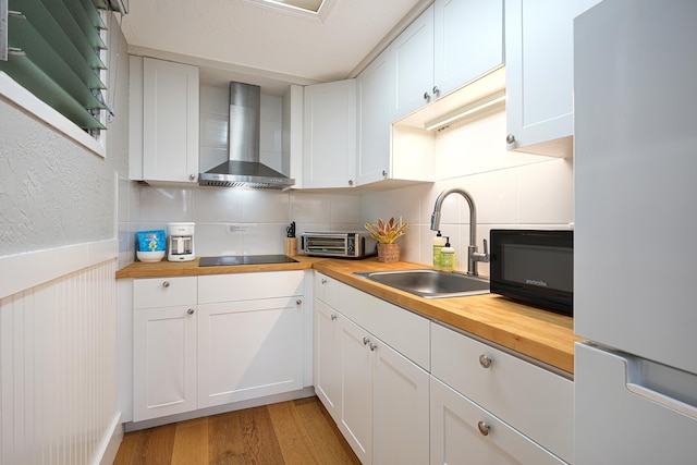 5061 Lawai Rd Unit 323, Koloa, HI 96756 - kitchen featuring freestanding refrigerator, wall chimney exhaust hood, wooden counters, a sink, and tasteful backsplash