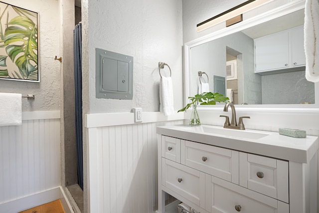 5061 Lawai Rd Unit 323, Koloa, HI 96756 - bathroom with electric panel, vanity, wainscoting, a textured wall, and curtained shower