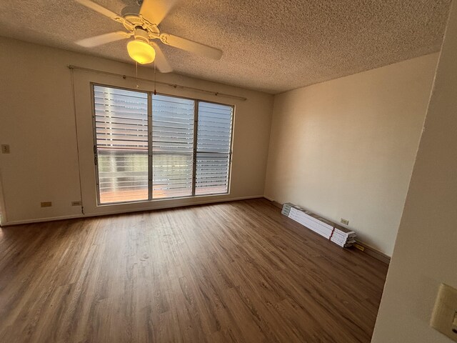 33 Hualalai St Unit 203, Hilo, HI 96720 - unfurnished room featuring wood finished floors, a textured ceiling, a ceiling fan, and baseboards