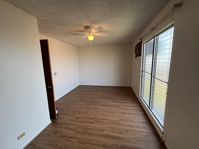 33 Hualalai St Unit 203, Hilo, HI 96720 - empty room with a textured ceiling, a ceiling fan, dark wood-type flooring, and baseboards