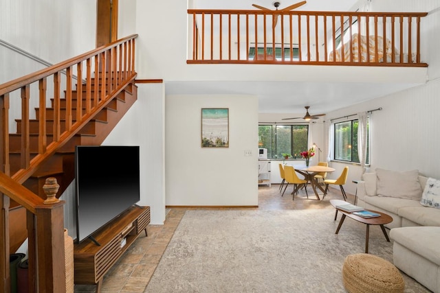 4465 Aku Rd, Hanalei, HI 96722 - living area with ceiling fan, a towering ceiling, stairway, stone finish flooring, and baseboards