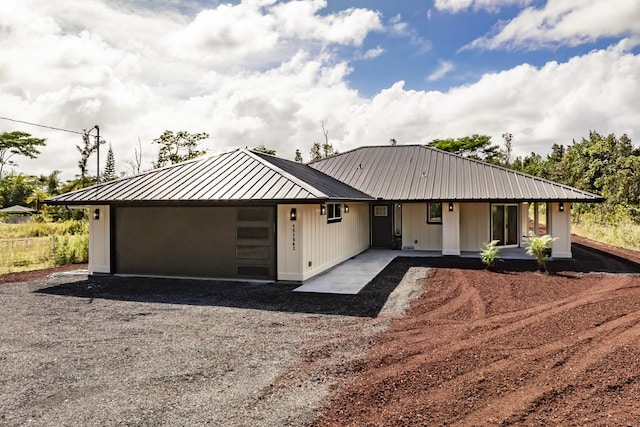 15-1042 Amau Rd, Keaau, HI 96749 - view of front of property featuring metal roof, gravel driveway, an attached garage, and a standing seam roof