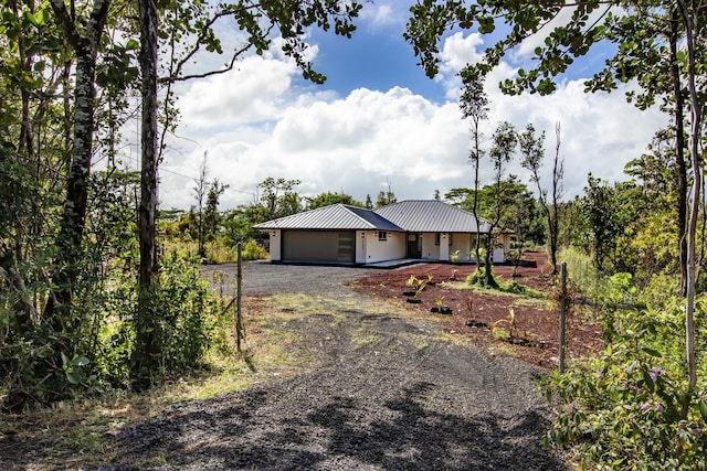 15-1042 Amau Rd, Keaau, HI 96749 - view of front facade featuring dirt driveway, an attached garage, and metal roof