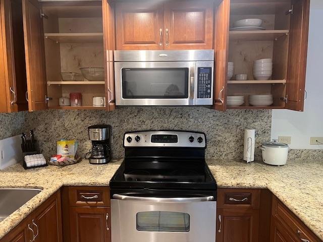 75-6040 Royal Sea Cliff Clb Unit 102, Kailua-Kona, HI 96740 - kitchen featuring appliances with stainless steel finishes, open shelves, and decorative backsplash