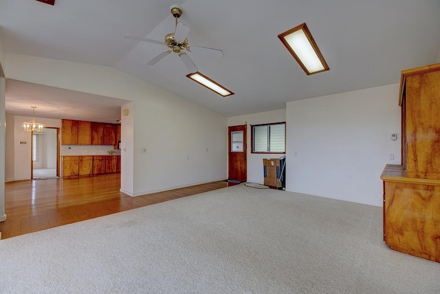17-549 Ipuaiwaha St, Keaau, HI 96749 - empty room featuring carpet flooring, lofted ceiling, ceiling fan, a chandelier, and wood finished floors