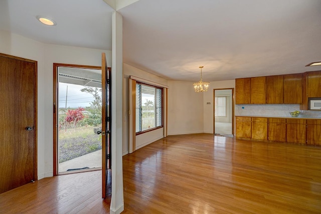 17-549 Ipuaiwaha St, Keaau, HI 96749 - kitchen featuring white microwave, brown cabinets, light wood-type flooring, a chandelier, and light countertops