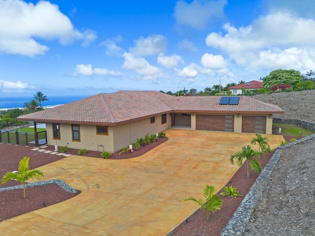 73-4460 Kohanaiki Rd, Kailua-Kona, HI 96740 - view of front of home with a tiled roof, concrete driveway, solar panels, stucco siding, and an attached garage