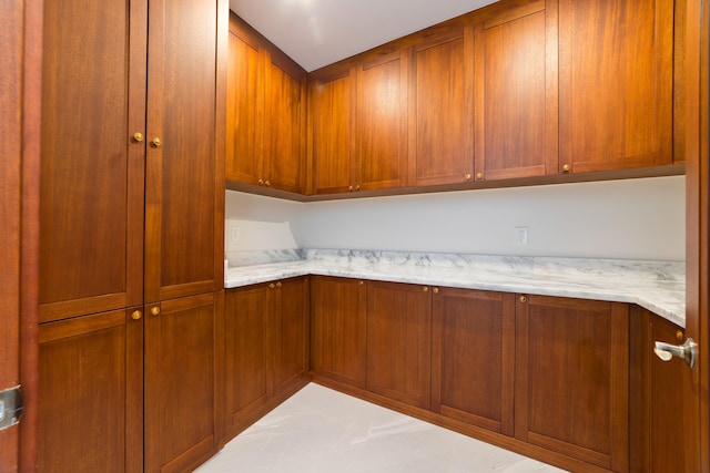 73-4460 Kohanaiki Rd, Kailua-Kona, HI 96740 - kitchen with light stone counters, brown cabinetry, and tile patterned flooring