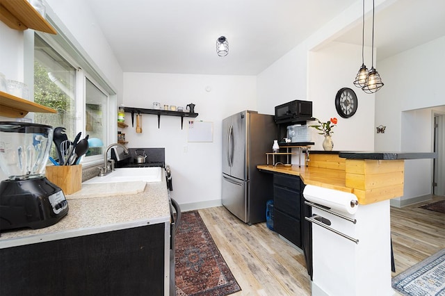 11-2775 Lehua St, Mountain View, HI 96771 - kitchen with open shelves, freestanding refrigerator, a sink, light wood-style flooring, and dark cabinetry