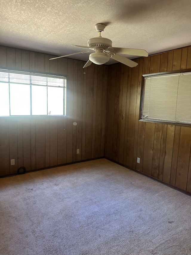 68-1809 Hooko St, Waikoloa, HI 96738 - unfurnished room with a textured ceiling, a ceiling fan, carpet floors, and wood walls