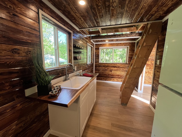 12-7010 Nahokulele St, Pahoa, HI 96778 - kitchen featuring a sink, wood walls, wood ceiling, butcher block countertops, and white cabinets