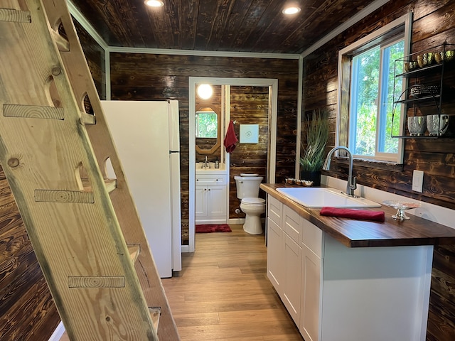 12-7010 Nahokulele St, Pahoa, HI 96778 - kitchen featuring a sink, butcher block countertops, wood walls, freestanding refrigerator, and wood-type flooring