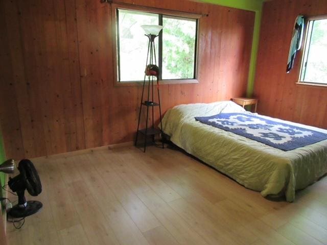12-567 Aloha Rd, Pahoa, HI 96778 - bedroom with wood walls and hardwood / wood-style floors