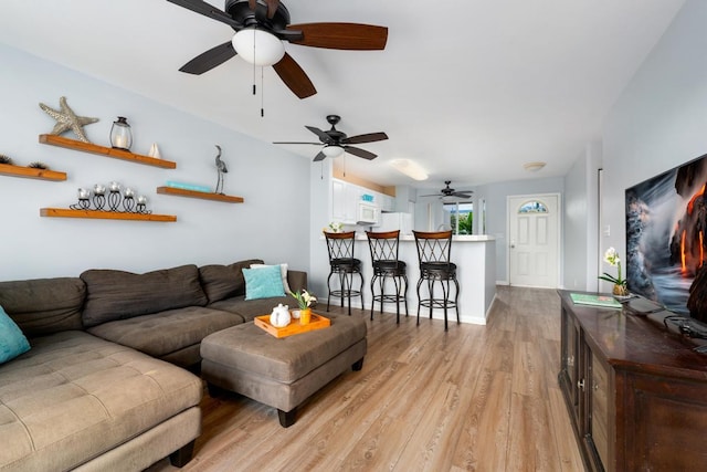 75-6081 Alii Dr Unit V101, Kailua-Kona, HI 96740 - living area with ceiling fan, light wood-type flooring, and baseboards