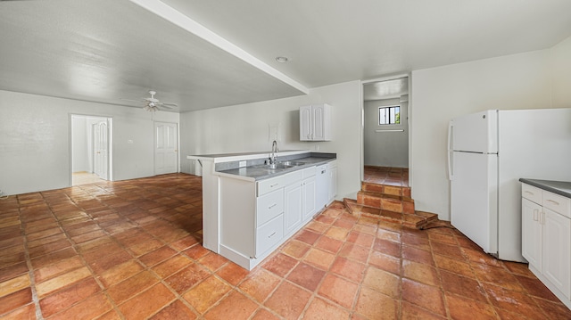 411 Molo St, Kapaa, HI 96746 - kitchen with freestanding refrigerator, a sink, a peninsula, ceiling fan, and white cabinets