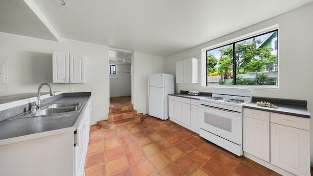 411 Molo St, Kapaa, HI 96746 - kitchen featuring white appliances, a sink, white cabinetry, and dark countertops