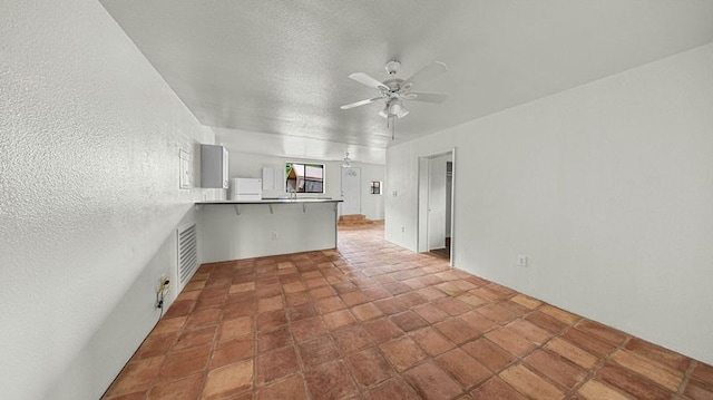 411 Molo St, Kapaa, HI 96746 - kitchen with ceiling fan, a peninsula, fridge, and a breakfast bar area