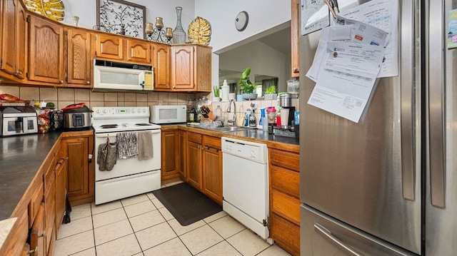 411 Molo St, Kapaa, HI 96746 - kitchen with white appliances, brown cabinetry, a sink, and dark countertops