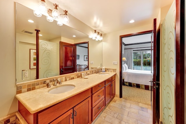 4-820 Kuhio Hwy Unit C104, Kapaa, HI 96746 - ensuite bathroom featuring double vanity, tasteful backsplash, recessed lighting, stone tile floors, and baseboards