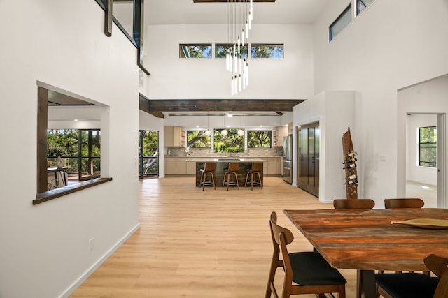 3973 Kalakaua Pl, Princeville, HI 96722 - dining area featuring light wood finished floors, a towering ceiling, a chandelier, and baseboards