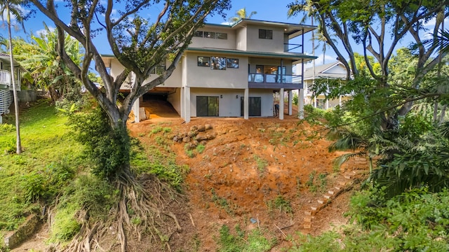 3973 Kalakaua Pl, Princeville, HI 96722 - back of house with a balcony, stucco siding, and stairway