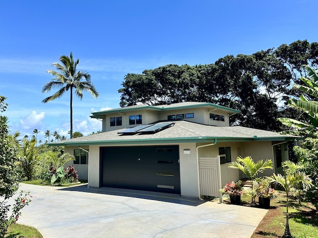 3973 Kalakaua Pl, Princeville, HI 96722 - prairie-style home featuring concrete driveway, stucco siding, roof mounted solar panels, and an attached garage
