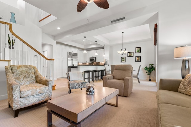 68-1118 N Kaniku Dr Unit 2104, Kamuela, HI 96743 - living area featuring light colored carpet, a tray ceiling, a ceiling fan, stairs, and a chandelier