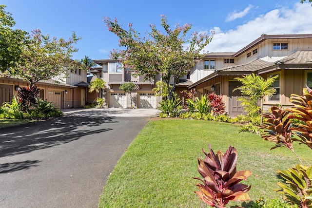 68-1118 N Kaniku Dr Unit 2104, Kamuela, HI 96743 - view of property featuring board and batten siding, driveway, a garage, a front yard, and a residential view