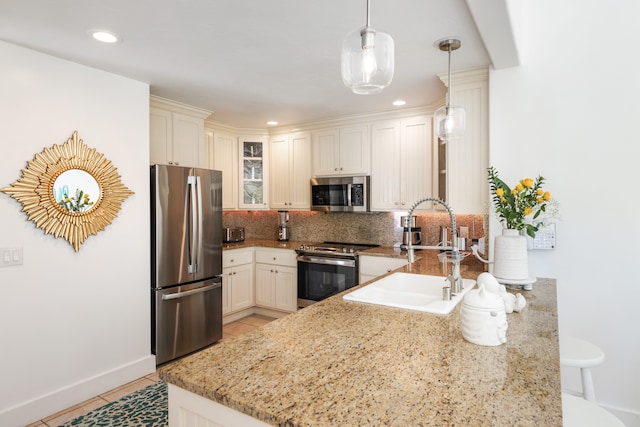 1831 Poipu Rd Unit 720, Koloa, HI 96756 - kitchen with stainless steel appliances, a sink, decorative backsplash, a peninsula, and glass insert cabinets