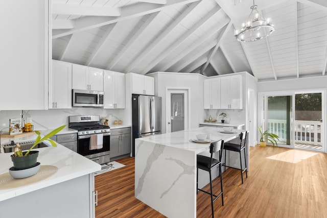 15-1632 6th Ave, Keaau, HI 96749 - kitchen featuring appliances with stainless steel finishes, a sink, a chandelier, wood finished floors, and light stone counters