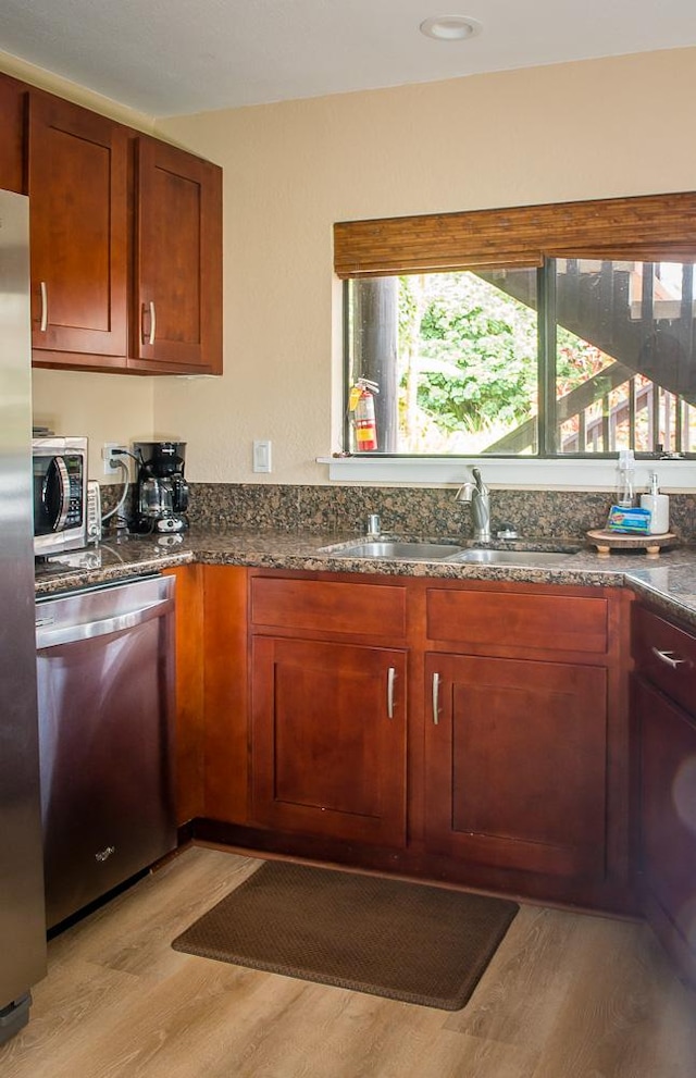 3920 Wyllie Rd Unit 9A, Princeville, HI 96722 - kitchen with appliances with stainless steel finishes, light wood finished floors, a sink, and dark stone counters