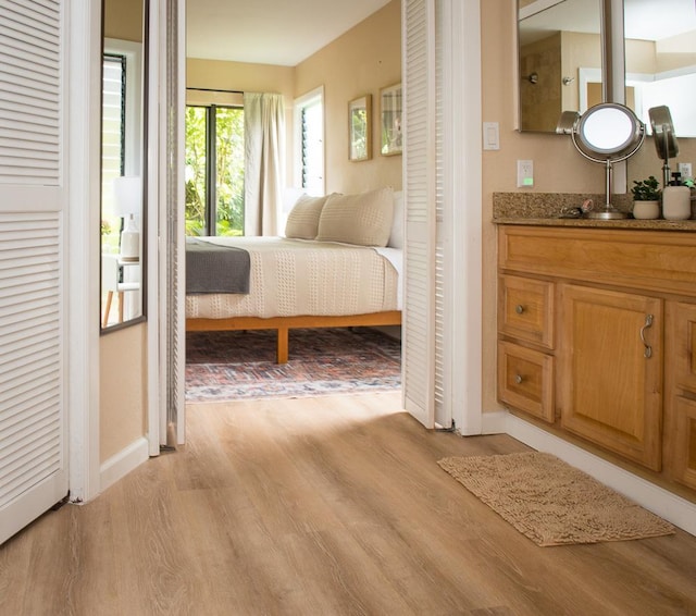 3920 Wyllie Rd Unit 9A, Princeville, HI 96722 - bedroom featuring light wood finished floors, baseboards, and a sink