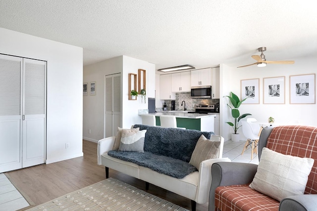 79-7199 Mamalahoa Hwy Unit 247, Holualoa, HI 96725 - living room with a ceiling fan, baseboards, light wood-style flooring, and a textured ceiling