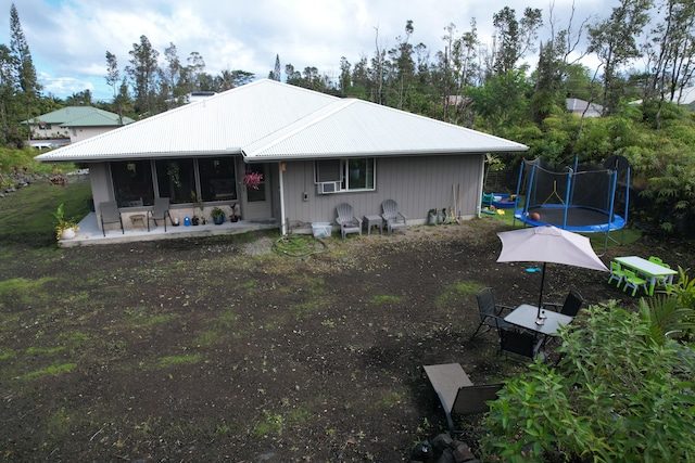 15-2804 Maiko St, Pahoa, HI 96778 - back of house featuring a trampoline, a patio area, metal roof, and view of scattered trees