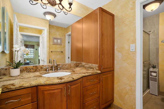 525 Aleka Lp Unit K12, Kapaa, HI 96746 - bathroom featuring a stall shower, vanity, a textured wall, a textured ceiling, and tile patterned floors