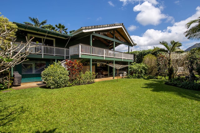 4446 Aku Rd, Hanalei, HI 96714 - rear view of house with stairs, a wooden deck, a yard, and a patio area