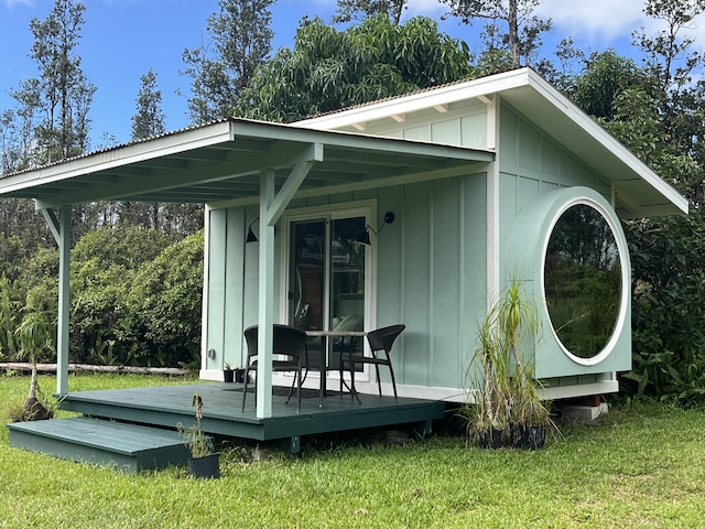 16-2000 Moho Rd, Mountain View, HI 96760 - view of side of home with board and batten siding, a deck, and a lawn