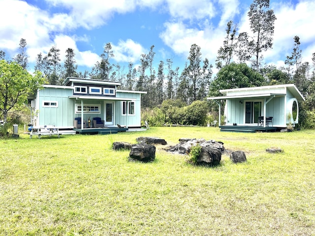 16-2000 Moho Rd, Mountain View, HI 96760 - back of house featuring covered porch, a fire pit, board and batten siding, and a yard