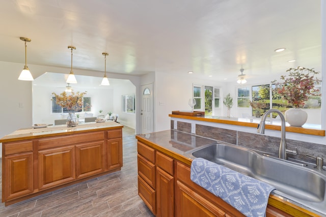 16-1321 Pohaku Cir, Keaau, HI 96749 - kitchen featuring a sink, a ceiling fan, pendant lighting, open floor plan, and brown cabinets