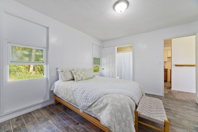 16-1321 Pohaku Cir, Keaau, HI 96749 - bedroom featuring dark wood-style floors, baseboards, and a textured ceiling