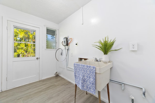 16-1321 Pohaku Cir, Keaau, HI 96749 - laundry area featuring electric dryer hookup, wood finished floors, baseboards, and a textured ceiling