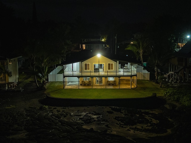 15-885 Paradise Ala Kai Dr, Keaau, HI 96749 - back of house at night with a lawn and a wooden deck