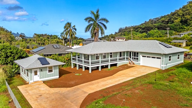 1264-D Crossley Rd, Kapaa, HI 96746 - view of front facade with driveway, roof mounted solar panels, board and batten siding, and a shingled roof