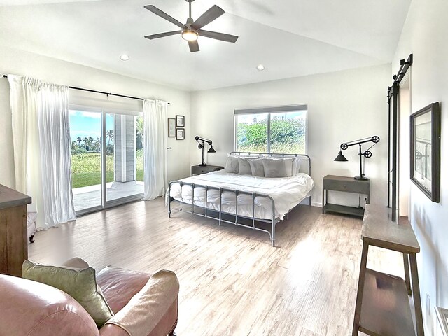 94-5774 Kalakau St, Naalehu, HI 96772 - bedroom with access to outside, wood finished floors, lofted ceiling, a barn door, and ceiling fan