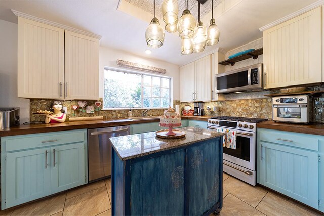 15-1559 19th Ave, Keaau, HI 96749 - kitchen with appliances with stainless steel finishes, blue cabinetry, decorative backsplash, a chandelier, and light tile patterned flooring