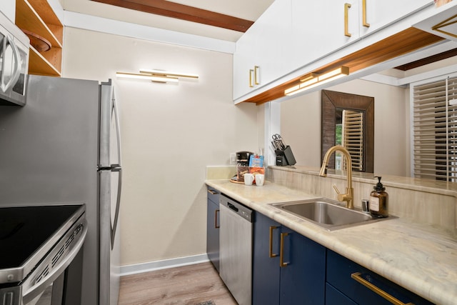 2253 Poipu Rd Unit 130, Koloa, HI 96756 - kitchen featuring blue cabinets, stainless steel dishwasher, a sink, baseboards, and light wood-type flooring
