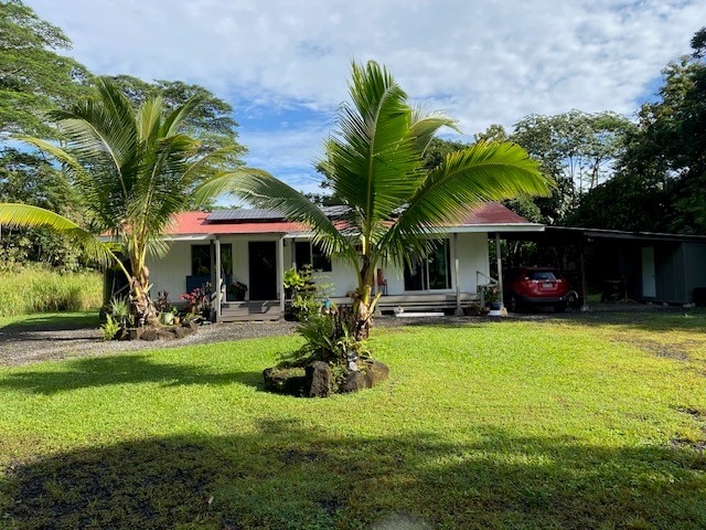 15-1949 11th Ave, Keaau, HI 96749 - back of property featuring solar panels, a lawn, and a carport