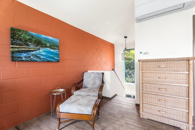 75-5855 Walua Rd Unit 15, Kailua-Kona, HI 96740 - sitting room featuring an AC wall unit and wood finished floors