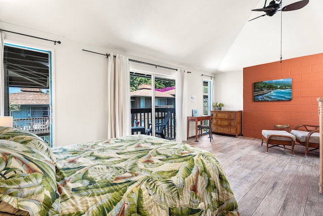 75-5855 Walua Rd Unit 15, Kailua-Kona, HI 96740 - bedroom with access to exterior, wood finished floors, lofted ceiling, and concrete block wall
